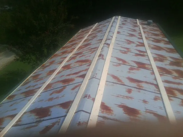 Rusted metal roof panels with new wood purlins before replacement — Storm Damage Roof Repair in Stuarts Draft by Roofing Brothers